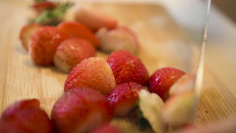 Nahaufnahme-Weiblicher-Hände,-Die-Köstliche-Erdbeerfrüchte-In-Der-Küche-Schneiden