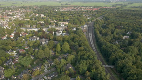 Aerial-of-train-tracks-running-next-to-a-beautiful-small-town