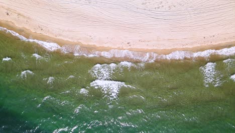 Drohnenclip-In-Zeitlupe-über-Einem-Wunderschönen-Strand-Mit-Kristallklarem-Wasser-Und-Wellen,-Die-Auf-Dem-Boden-In-Keramoti,-Kavala,-Nordgriechenland-Zermalmen