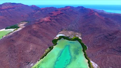 Reverse-Flying-Drone-to-Reveal-Striking-Desert-Mountain-Valley-Leading-towards-Unique-Underwater-Algae-and-Sand-Formations