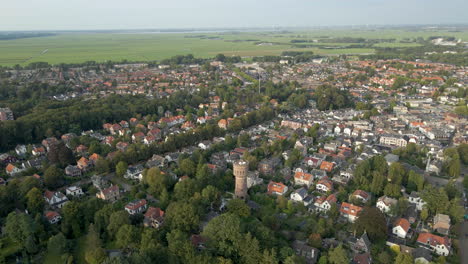 Aerial-of-old-water-tower-standing-in-a-modern,-suburban-neighborhood