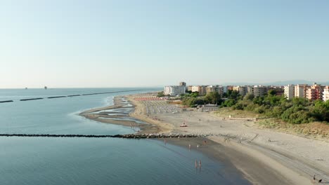 Aerial-shot-of-sandy-beach-with-umbrellas,-typical-adriatic-shore