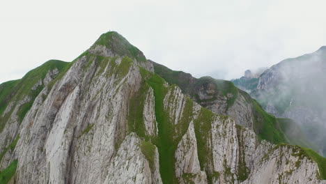 Revealing-drone-shot-on-a-mountain-peak-located-in-the-canton-of-Appenzell-Innerrhoden-in-Switzerland
