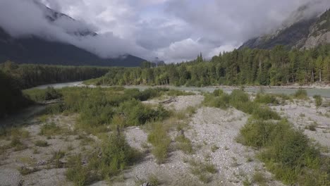 Low-cloudy-aerial-flight-over-gravel-bar-in-flowing-Bella-Coola-River