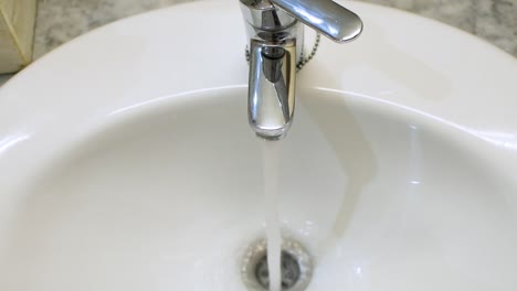 Open-tap-in-the-sink-with-running-water