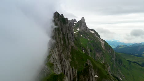 Cinematic-rotating-drone-shot-starting-in-the-clouds-then-revealing-Altenalp-Turm-in-Switzerland