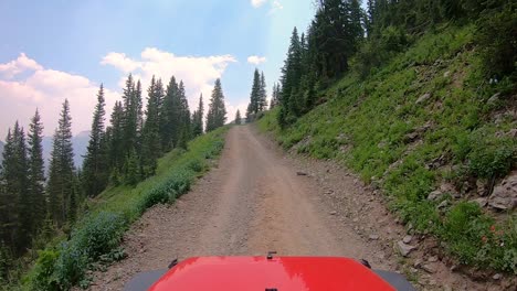 POV-over-the-hood-of-vehicle-on-narrow-off-road-trail-trail-cut-into-the-mountain-side