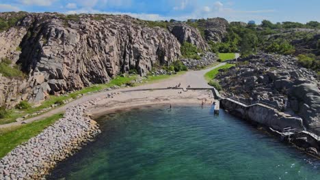 Aerial-View-Of-People-In-Langevik-Beach-With-Rocky-Shore-And-Cliff-In-Lysekil,-Sweden