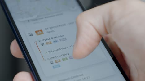 Hand-Halten-Und-Scrollen-Mobiltelefon-Mit-Mobilitätsplaner-app-Auf-Dem-Bildschirm