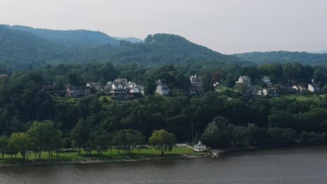Aerial-drone-video-footage-of-Cornwall-on-Hudson-in-Orange-County-New-York,-in-New-York's-Hudson-Valley-as-seen-from-the-Hudson-River-with-the-Appalachian-Mountains-in-the-background