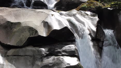 Rainforest-waterfall-erodes-stone-into-smooth-rock-sculpture-over-eons