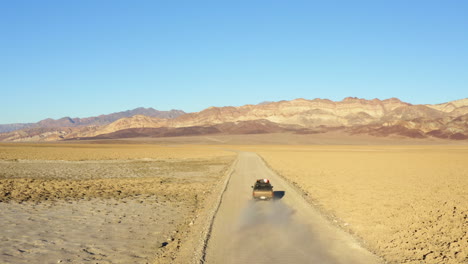 Aerial-view-of-single-SUV-jeep-on-road-amidst-hot-dry-barren-terrain-of-Death-valley-national-park