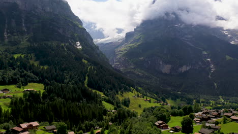 Wide-drone-shot-of-Grindelwald,-a-village-in-Switzerland’s-Bernese-Alps,-with-the-mountains-in-the-background