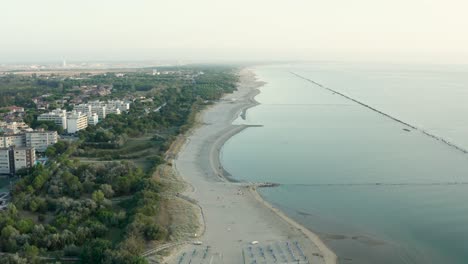 Aerial-shot-of-sandy-beach-with-umbrellas,-typical-adriatic-shore