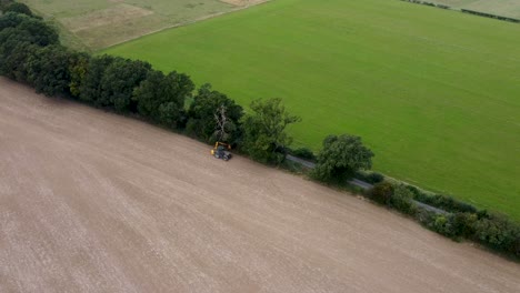 Aerial-View-Of-Hedge-Being-Trimmed-By-Tractor-In-Field