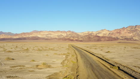 Vista-De-Pájaro-De-La-Carretera-En-Medio-Del-Terreno-árido-Seco-Y-Caliente-Del-Parque-Nacional-Del-Valle-De-La-Muerte