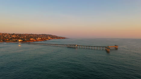 Malerischer-Ocean-Beach-Pier-Mit-Lebendigen-Sonnenuntergangsfarben-Während-Der-Goldenen-Stunde,-Luftaufnahme