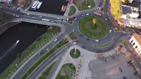 Aerial-flyover-bus-roundabout-and-cruising-boat-on-river-in-Tigre,Buenos-Aires---Argentina,South-America