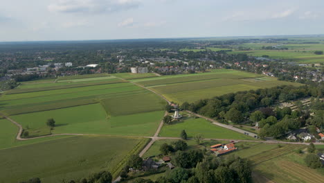 Fliegen-In-Richtung-Drehender-Windmühle-In-Einer-Schönen-Grünen-Ländlichen-Stadt