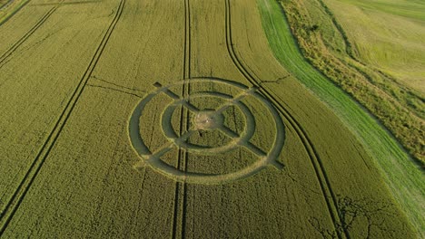 Hackpen-hill-strange-crop-circle-symbols-in-rural-grass-farming-meadow-aerial-view-rising-tilt-down