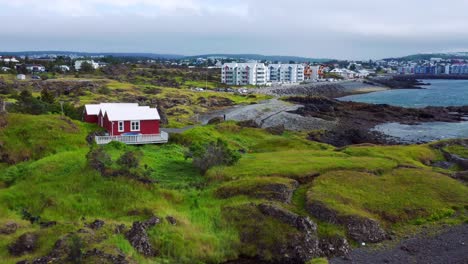 Rugged-Terrain-And-High-Rise-Buildings-At-The-Seafront-In-Gardabaer,-Iceland