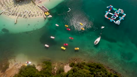 Tilt-up-over-beautiful-Ksamil-Beach-with-colorful-boats