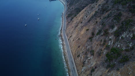 Aerial-View-High-up-as-Car-Drives-Along-Santa-Catalina-Coastal-Highway-Road,-California,-Reveal-Shot