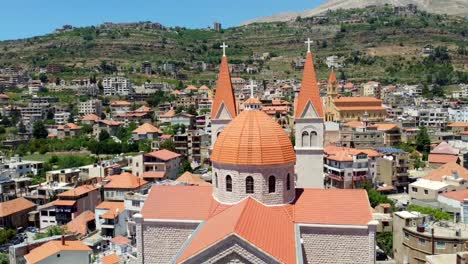Beautiful-orange-roofed-cathedral-overlooking-the-city-in-Lebanon--Aerial