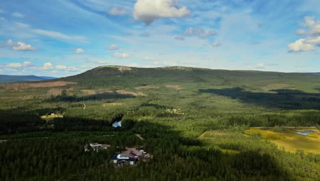 Green-Mountain,-Lush-Vegetation-And-Blue-Cloudy-Sky-In-Sälen,-Dalarna,-Sweden---aerial-drone-shot