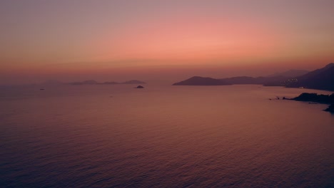 Wunderschöne-Drohnenaufnahme-Einer-Natürlichen-Küste-Während-Des-Sonnenuntergangs,-Das-Licht-Ist-Klar,-Rot-Und-Golden-Und-Das-Meer-Reflektiert-Diese-Farben