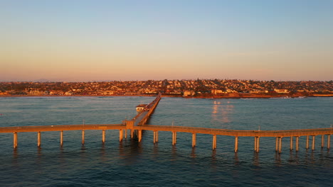 Sunset-over-Ocean-Beach-Pier,-San-Diego-California,-drone-sideways