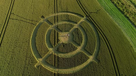 Hackpen-hill-strange-crop-circle-pattern-in-rural-grass-farming-meadow-aerial-view-birdseye-pull-back-shot