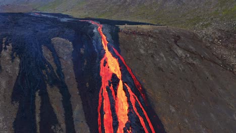 Fagradalsfjall-Vulkanausbruch---Luftaufnahme-Von-Menschen,-Die-Beobachten,-Wie-Lava-Durchbrochen-Wird-Und-Im-Natthagi-tal-In-Island-Herunterfließt