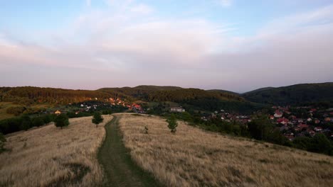 Timelapse-video-from-Hungary,-Bükkszentkereszt-lookout-tower,-dirt-road-leads-to-the-mountains-through-the-village-at-sunset