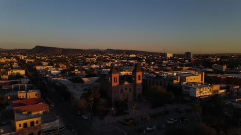Aerial:-dusk-sunset-over-La-Paz-city-buildings-in-Baja-California-Sur,-Mexico