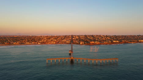 Muelle-De-La-Playa-Del-Océano-Durante-El-Crepúsculo,-Perspectiva-De-Drones
