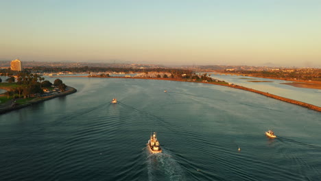 Fleet-of-boats-coming-come-in-entrance-channel-to-Mission-Bay,-San-Diego-California