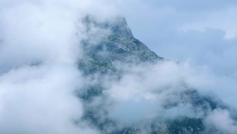 Timelapse-of-cloud-covering-blue-mountain-peak-with-tower-on-top