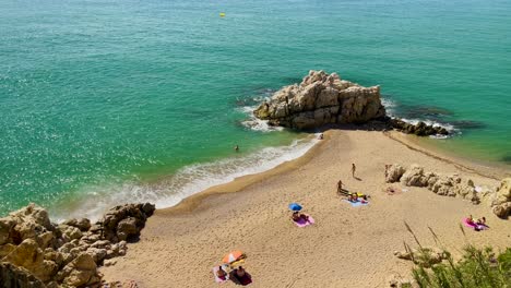 Costa-Brava-Cala-Roca-Grossa-Sonniger-Sommertag-Mittelmeer-Europäisch-Tourismus-Paradies-Strand-Luftaufnahme-Von-Drohne-Kontrast-Mit-Steinsand-Und-Grünen-Bäumen