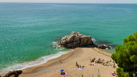 Cala-Roca-Grossa-sunny-summer-day-mediterranean-european-tourism-Paradise-beach-aerial-view-from-drone-contrast-with-rock-sand-and-green-trees