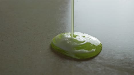 Klebrige-Grüne-Flüssigkeit-Mit-Weißem-Schaum-Auf-Glänzende-Oberfläche-Gießen