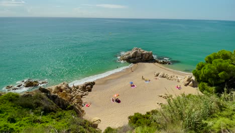 Cala-Roca-Grossa-Sonniger-Sommertag-Mittelmeer-Europäisch-Tourismus-Paradies-Strand-Luftaufnahme-Von-Drohne-Kontrast-Mit-Steinsand-Und-Grünen-Bäumen-Barcelone-Spanien-Costa-Brava