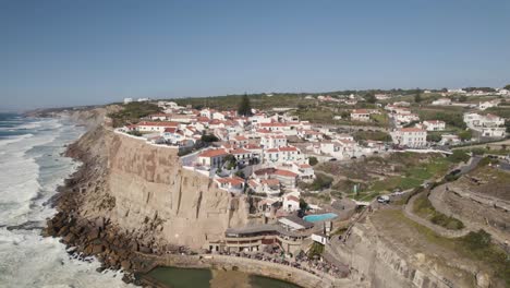 Establishing-pan-shot-overlooking-parish-town-on-top-of-the-cliff-in-Azenhas-do-Mar-with-waves-crashing-the-shore