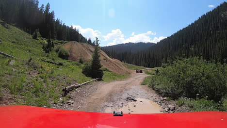 POV-over-red-hood-of-4WD-vehicle-on-Alpine-Loop-Trail-following-2-other-off-road-vehicles-in-Animas-River-valley-near-Silverton-Colorado-in-the-San-Juan-Mountains