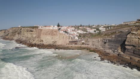 Long-powerful-waves-washing-on-rocky-coast-and-cliffs,-Azenhas-do-Mar,-Portugal