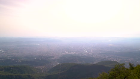 High-above-view-with-wide-open-landscape-and-polluted-city-in-background