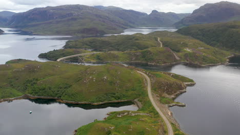 Drohnenaufnahme-Der-Kylesku-Brücke,-Die-Einem-Auto-Folgt,-Im-Nordwesten-Schottlands,-Das-Den-Loch-A&#39;cairn-Báin-In-Sutherland-überquert