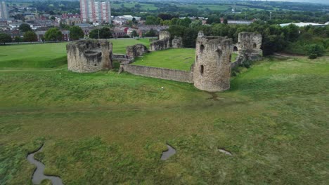 Flint-castle-Welsh-medieval-coastal-military-fortress-ruin-aerial-view-fast-pull-back-establishing