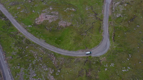 Downward-angle-drone-shot-of-vehicles-on-Bealach-Na-Ba-Applecross-road-through-the-mountains-of-the-Applecross-peninsula,-in-Wester-Ross-in-the-Scottish-Highlands