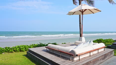 Premium-daybed-with-cushions-Under-Umbrella-at-outdoor-tropical-beach-Lounge-with-a-picturesque-sea-view-on-sunny-day